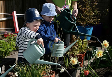 Two boys watering the garden